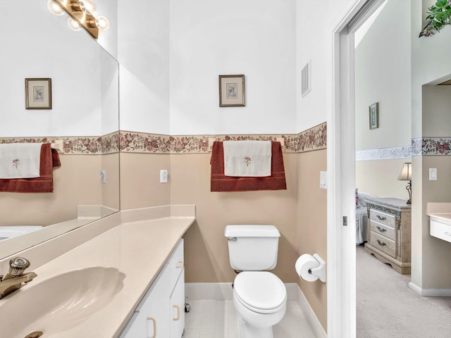 bathroom featuring tile patterned flooring, vanity, and toilet