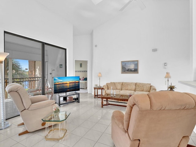 living room with a high ceiling, ceiling fan, and light tile patterned flooring