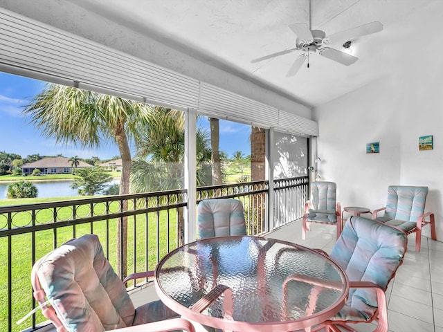 sunroom / solarium with ceiling fan and a water view