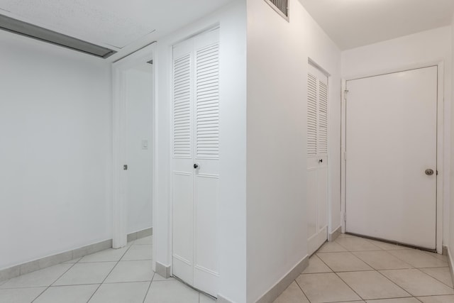 hall featuring light tile patterned floors