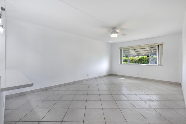 unfurnished room with ceiling fan and light tile patterned floors