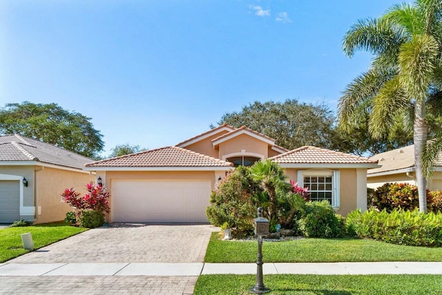 mediterranean / spanish-style home with a garage and a front lawn