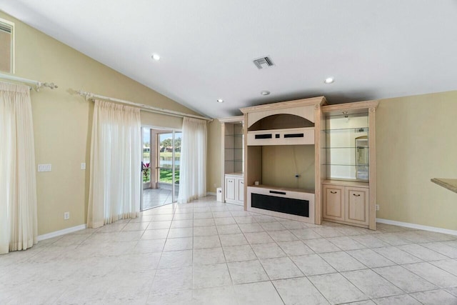 unfurnished living room with light tile patterned floors and vaulted ceiling