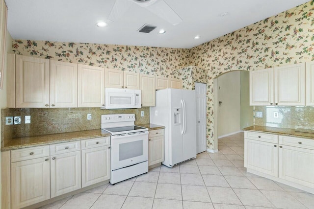 kitchen with decorative backsplash, white appliances, light stone counters, and light tile patterned flooring