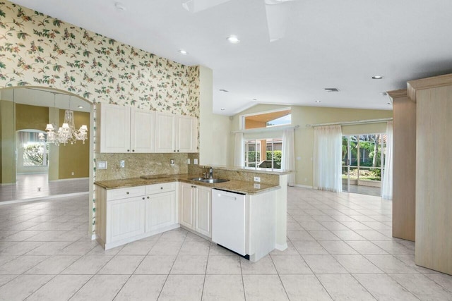 kitchen featuring dishwasher, lofted ceiling, stone counters, sink, and kitchen peninsula