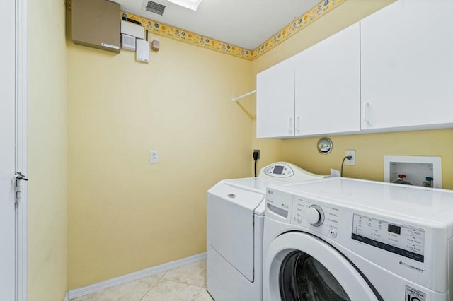 washroom featuring light tile patterned floors, cabinets, and independent washer and dryer