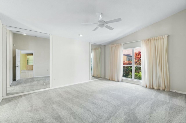 carpeted spare room with ceiling fan and lofted ceiling