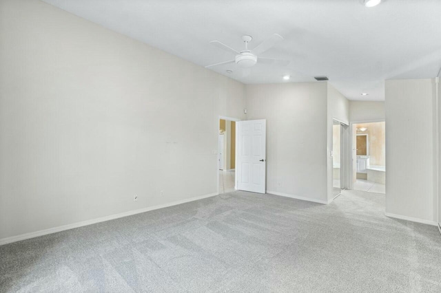 carpeted empty room with ceiling fan and a towering ceiling