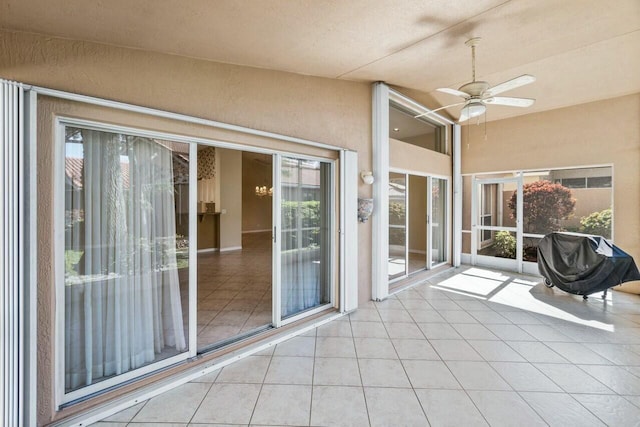 unfurnished sunroom with ceiling fan