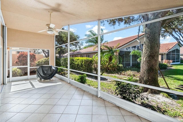 unfurnished sunroom featuring ceiling fan