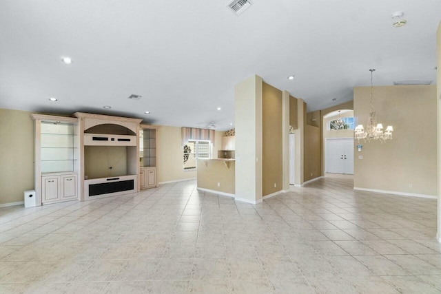 unfurnished living room with built in features, light tile patterned floors, and an inviting chandelier