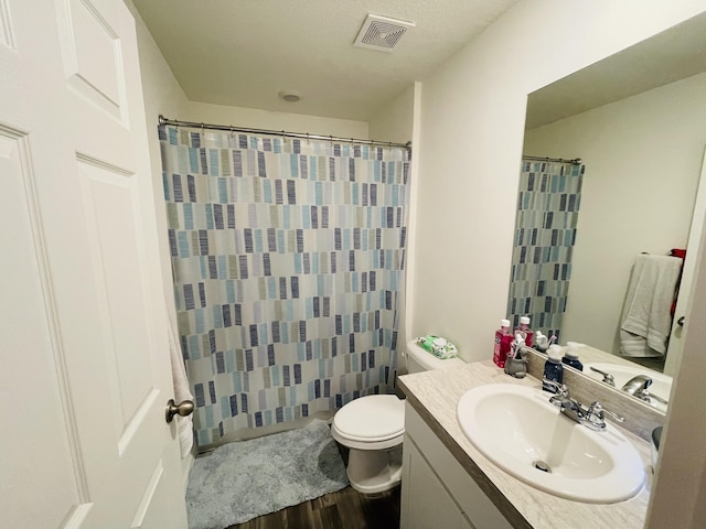 bathroom with a shower with shower curtain, hardwood / wood-style floors, vanity, and toilet