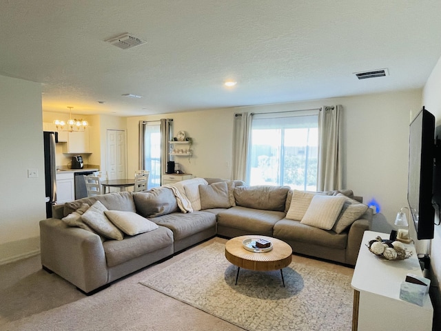 living room with a notable chandelier, a textured ceiling, and light carpet