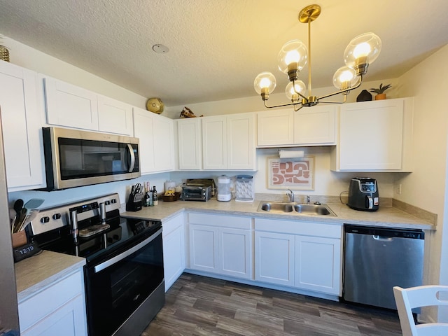 kitchen with white cabinetry, sink, hanging light fixtures, and appliances with stainless steel finishes