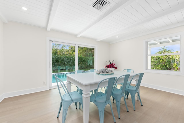 dining area with beam ceiling and light wood-type flooring