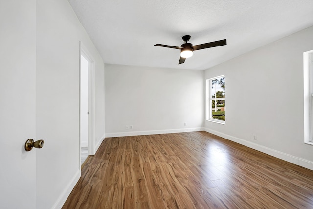 empty room featuring ceiling fan, hardwood / wood-style floors, and a textured ceiling