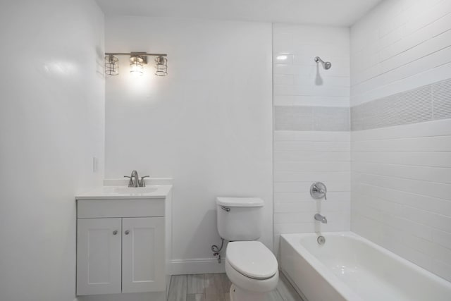 full bathroom with vanity, tiled shower / bath, wood-type flooring, and toilet