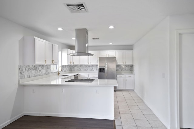 kitchen featuring white cabinetry, island exhaust hood, kitchen peninsula, and stainless steel refrigerator with ice dispenser