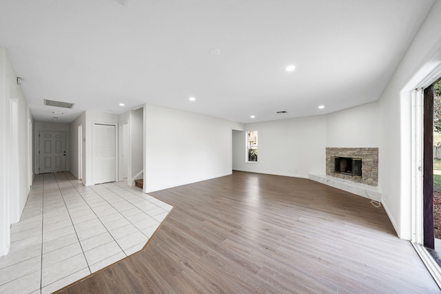 unfurnished living room with a fireplace and light hardwood / wood-style floors