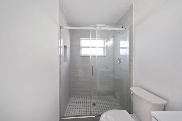 bathroom featuring toilet, vanity, and a shower with shower door