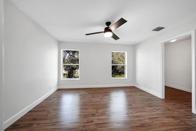 empty room featuring ceiling fan, dark hardwood / wood-style floors, and a textured ceiling