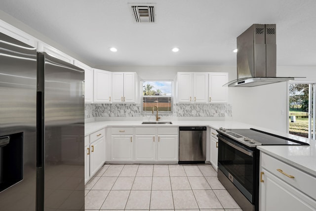 kitchen featuring white cabinets, sink, light tile patterned floors, appliances with stainless steel finishes, and island exhaust hood