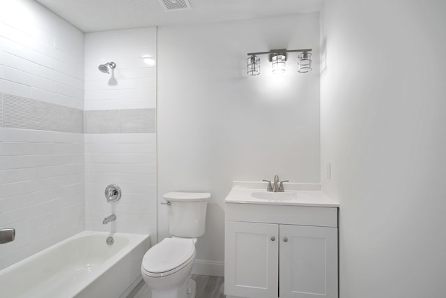 full bathroom with tiled shower / bath combo, vanity, hardwood / wood-style flooring, and toilet