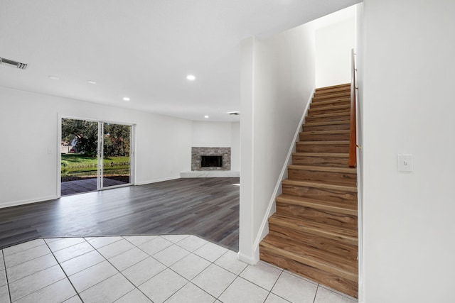 stairway featuring a fireplace and tile patterned flooring