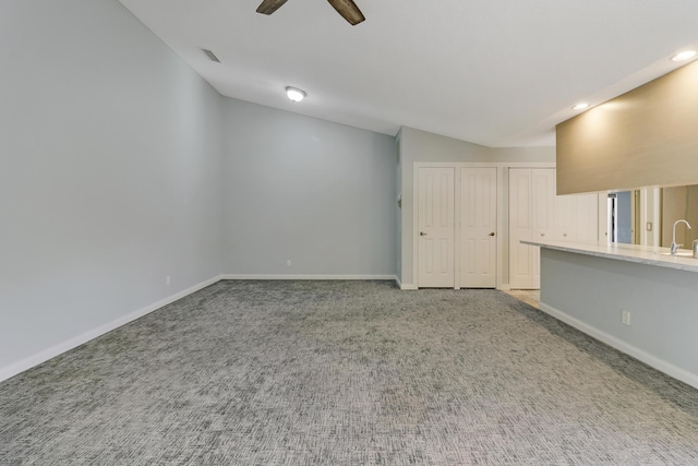 unfurnished room featuring light carpet, vaulted ceiling, ceiling fan, and sink