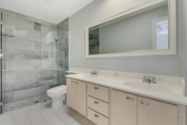 bathroom with tile patterned floors, vanity, toilet, and an enclosed shower