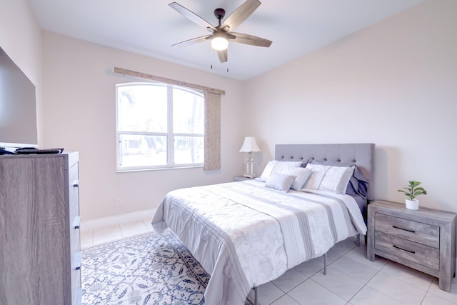 bedroom with light tile patterned flooring, ceiling fan, and baseboards