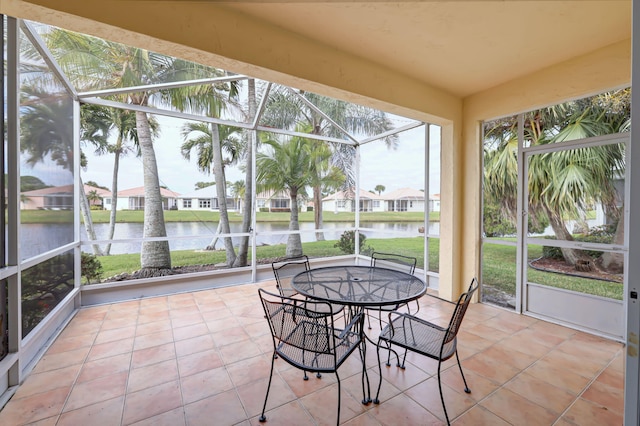 sunroom / solarium with a water view and a residential view