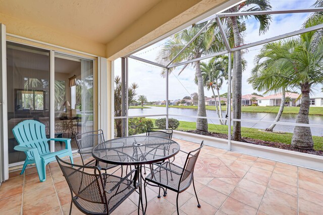 sunroom / solarium with a water view, a healthy amount of sunlight, and ceiling fan