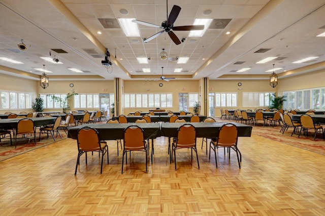 dining area with a drop ceiling, a healthy amount of sunlight, and ceiling fan