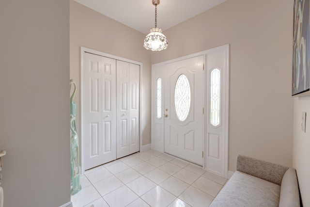 tiled entrance foyer with an inviting chandelier