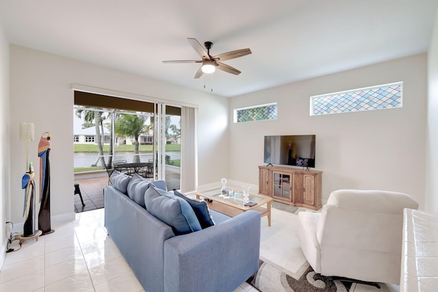 living room with light tile patterned floors, a ceiling fan, and baseboards