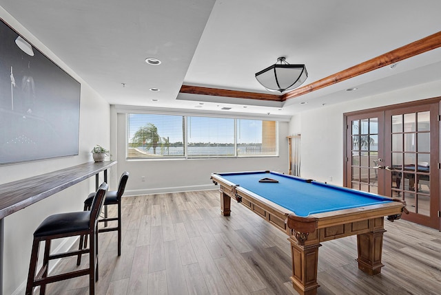 game room with light hardwood / wood-style floors, french doors, billiards, and a tray ceiling