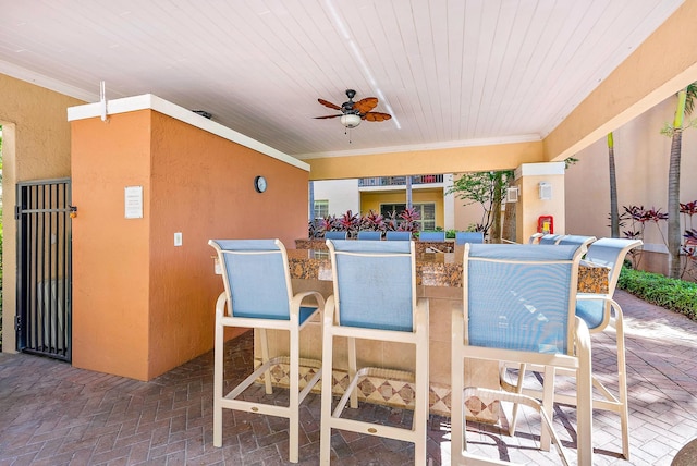 view of patio featuring a bar and ceiling fan