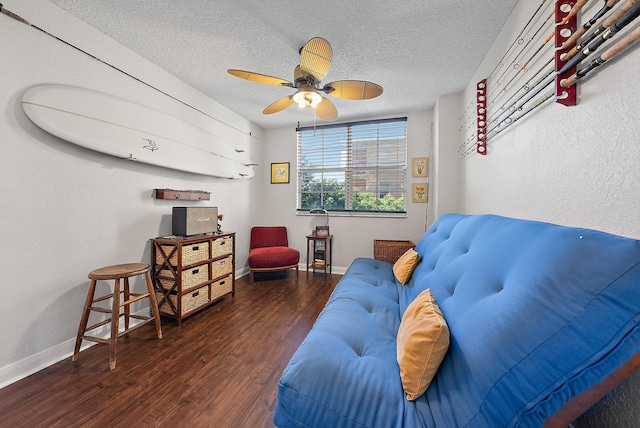 living room with a textured ceiling, dark hardwood / wood-style flooring, and ceiling fan