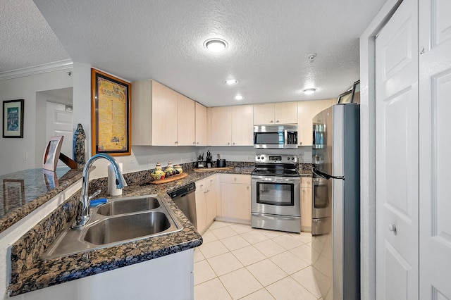 kitchen featuring sink, light tile patterned floors, a textured ceiling, and appliances with stainless steel finishes