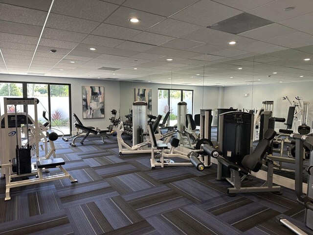 exercise room with carpet floors and a drop ceiling