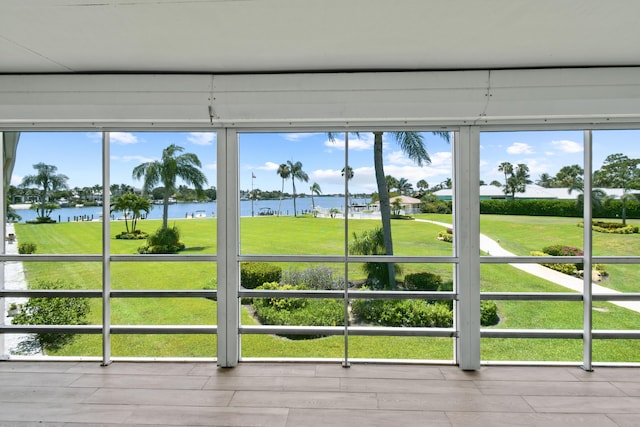 unfurnished sunroom with a water view and a healthy amount of sunlight