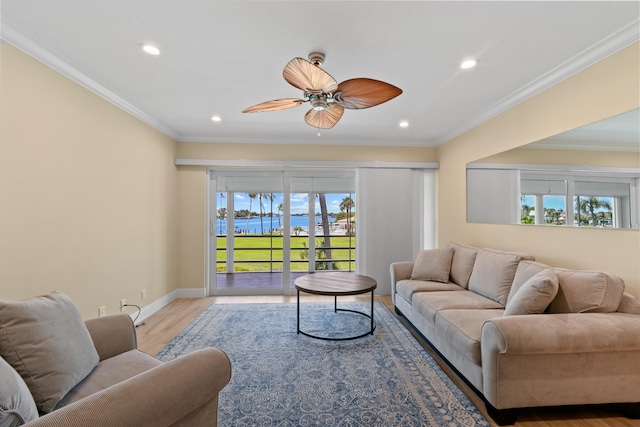 living room with light hardwood / wood-style floors, ceiling fan, and crown molding