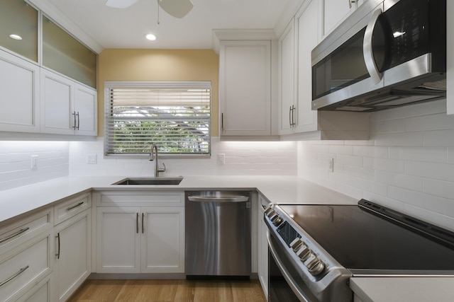 kitchen featuring white cabinets, sink, decorative backsplash, ceiling fan, and stainless steel appliances