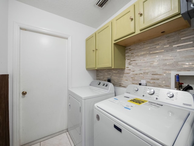 laundry room featuring cabinets, separate washer and dryer, and light tile patterned flooring