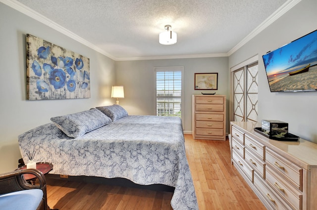 bedroom with ornamental molding, a textured ceiling, and light hardwood / wood-style flooring