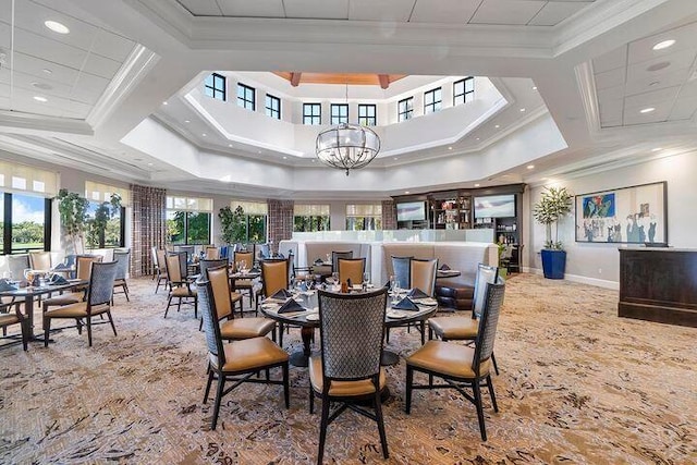 dining space with a healthy amount of sunlight, crown molding, and a chandelier