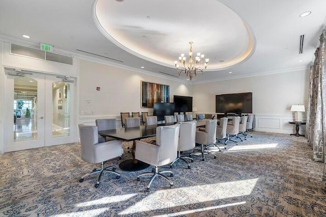 dining room featuring a tray ceiling, crown molding, carpet, and a chandelier