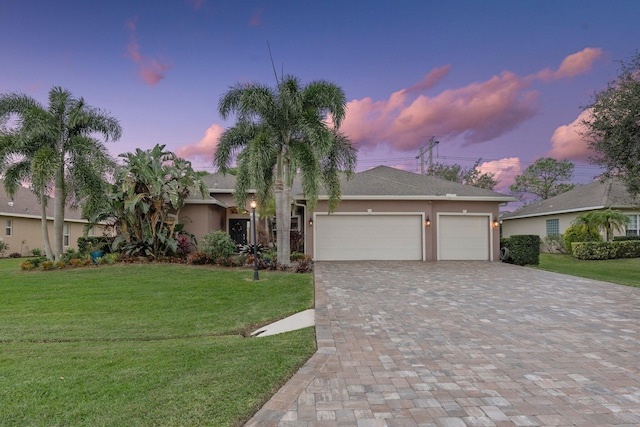 view of front facade with a lawn and a garage