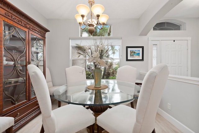 dining room with light wood-type flooring and a chandelier